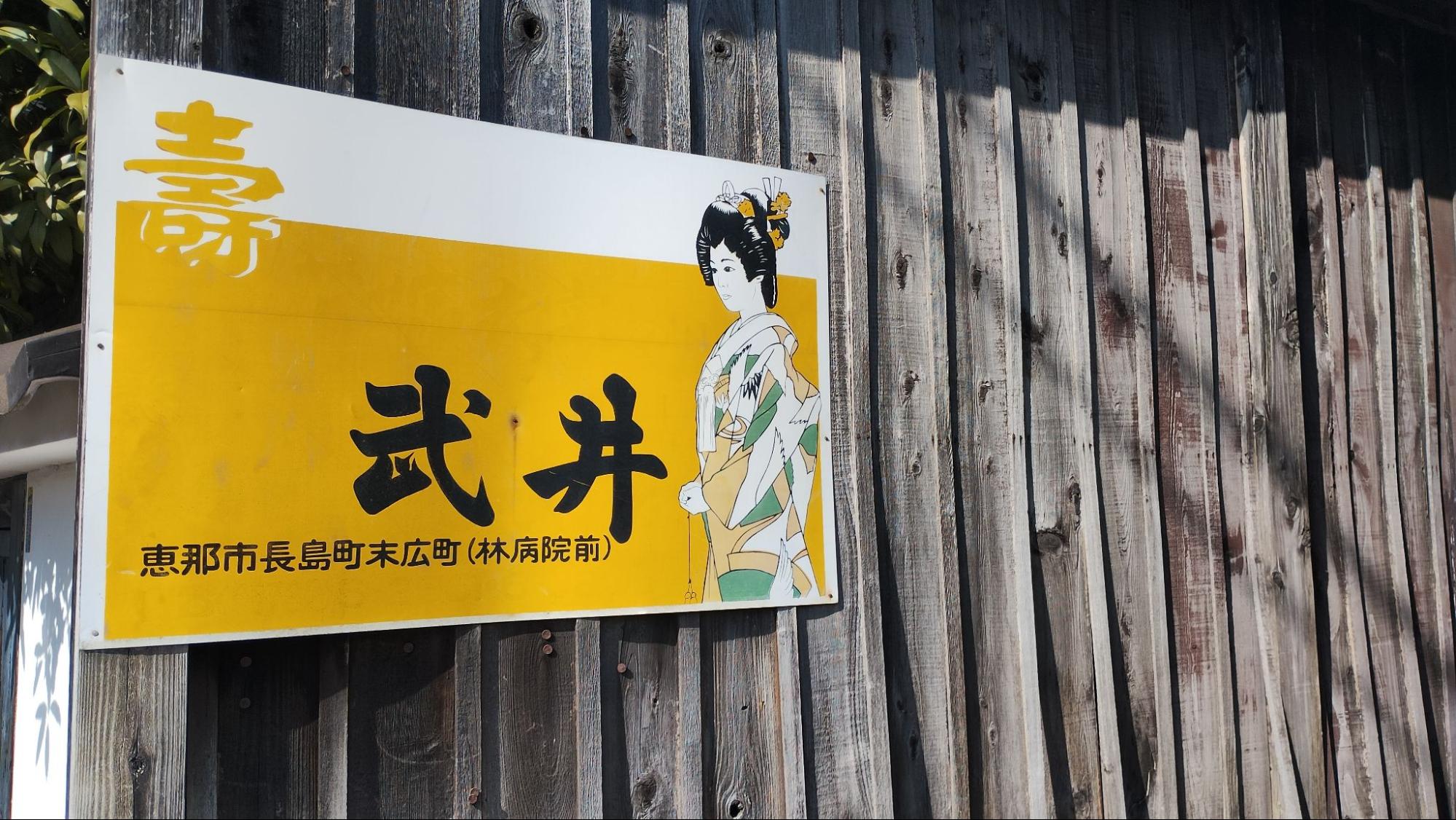 A vintage enamel signboard on a wooden fence