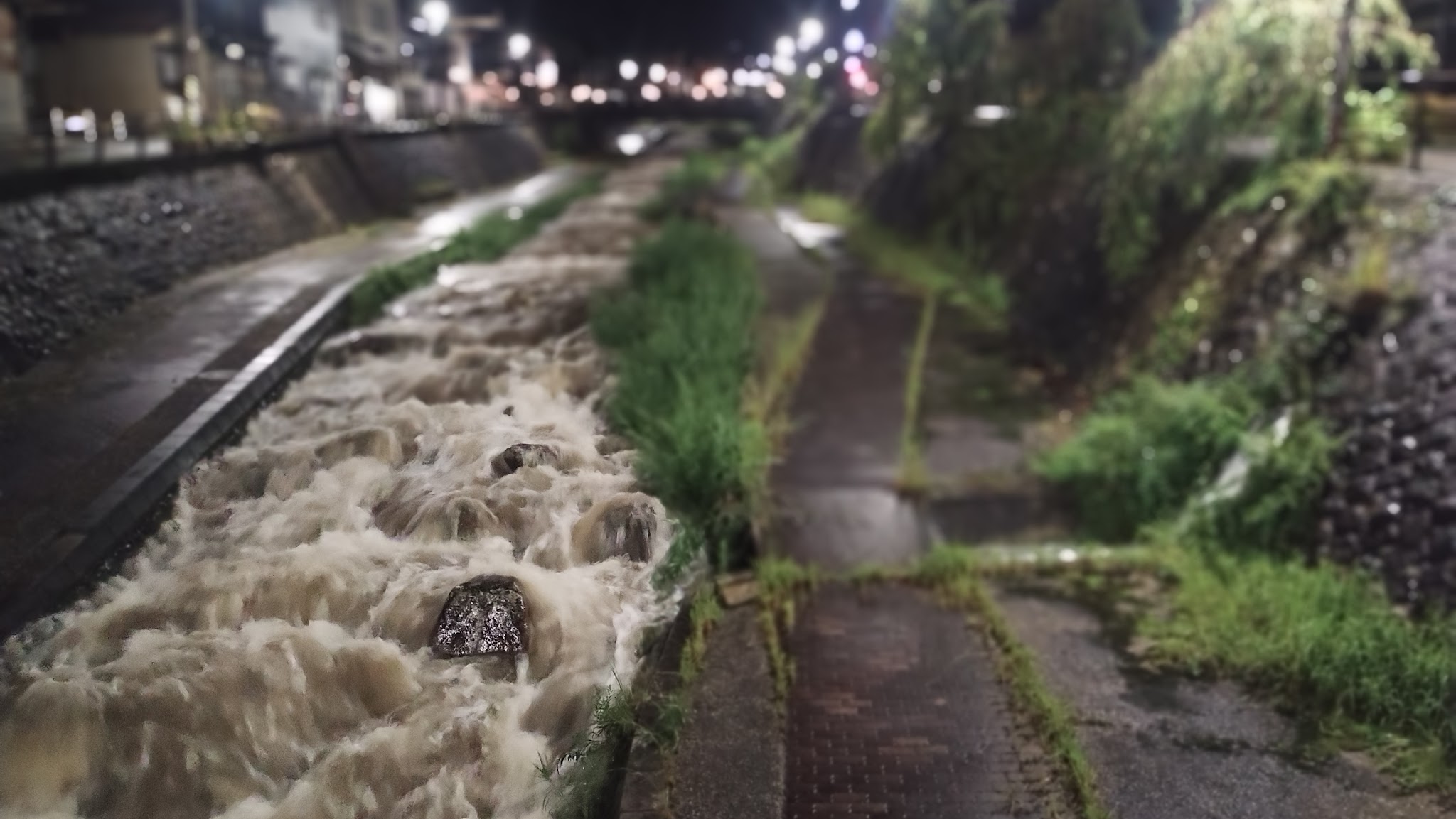 A swollen river at night after rain